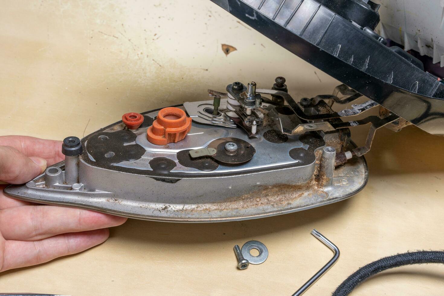 Disassembled electric iron. repairman checking and fixing broken iron photo