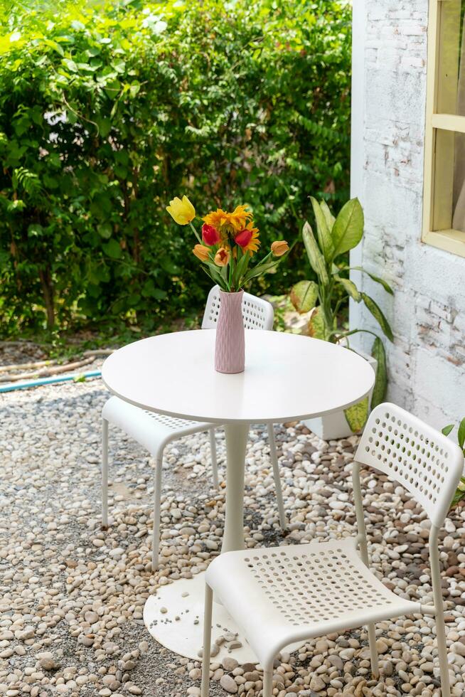 Vase with beautiful flowers on table in outdoor photo