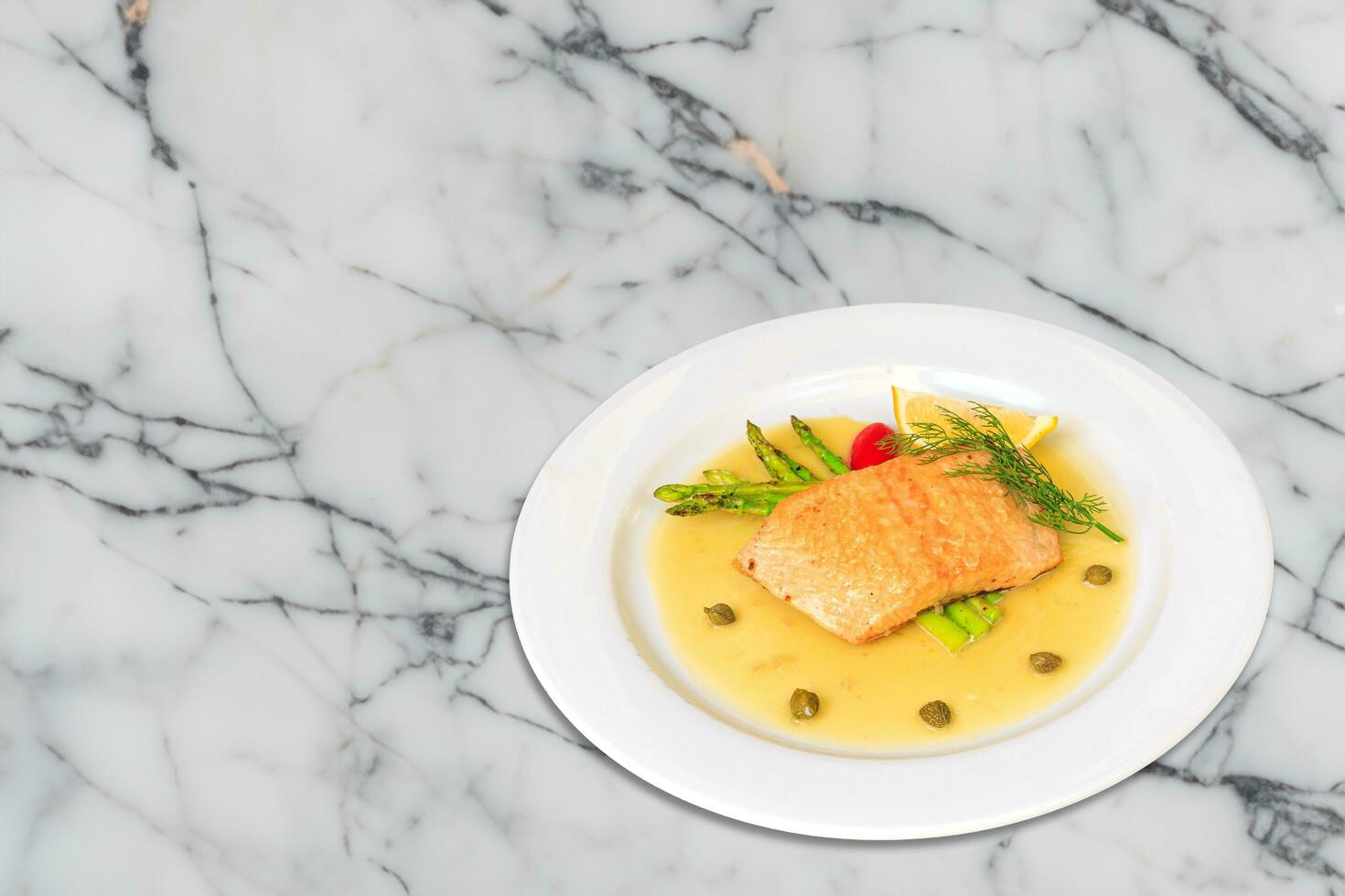 Salmon steak on the grill with asparagus  and herbs on white plate photo