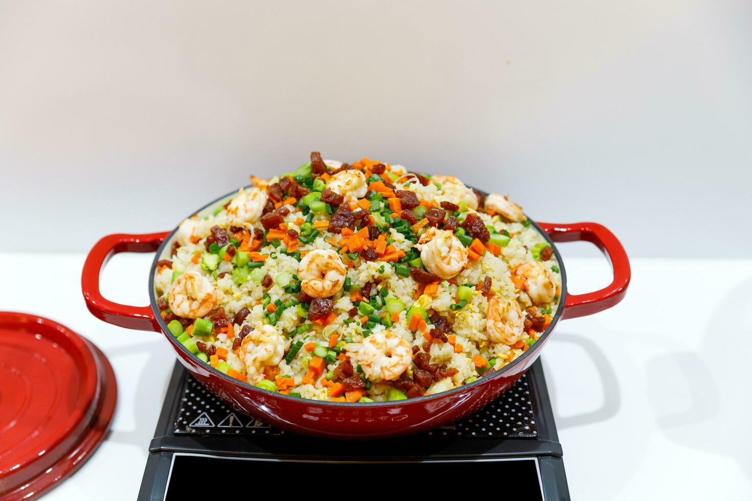 Stir fry rice with vegetables and shrimps in Red iron pan. Slate background. Top view. photo