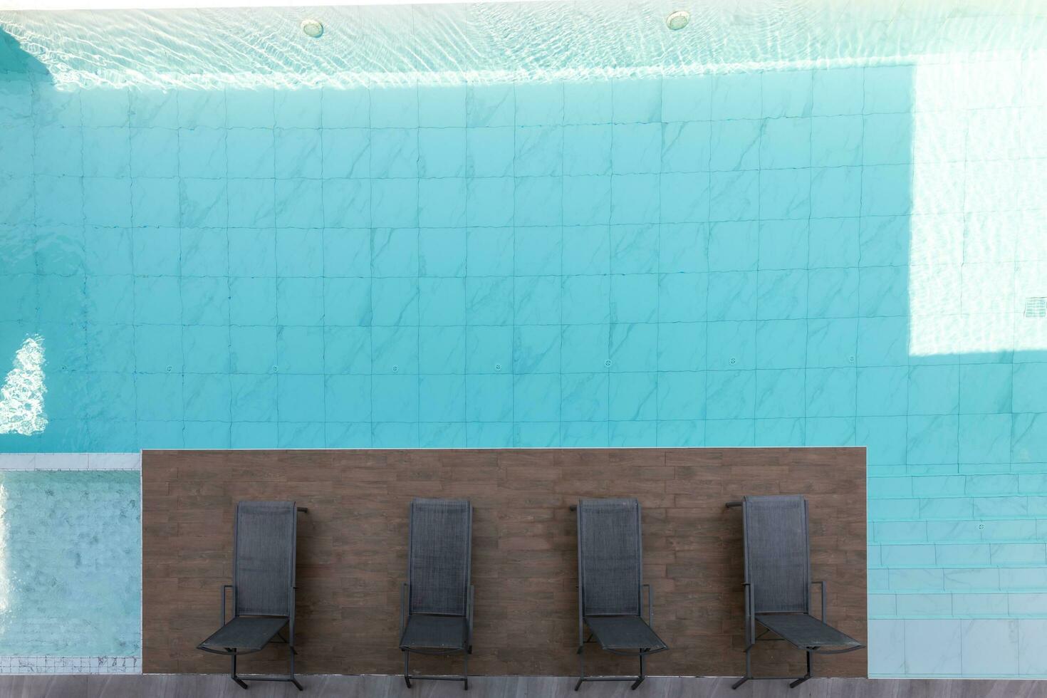 A top view from a swimming pool, with wood chair photo