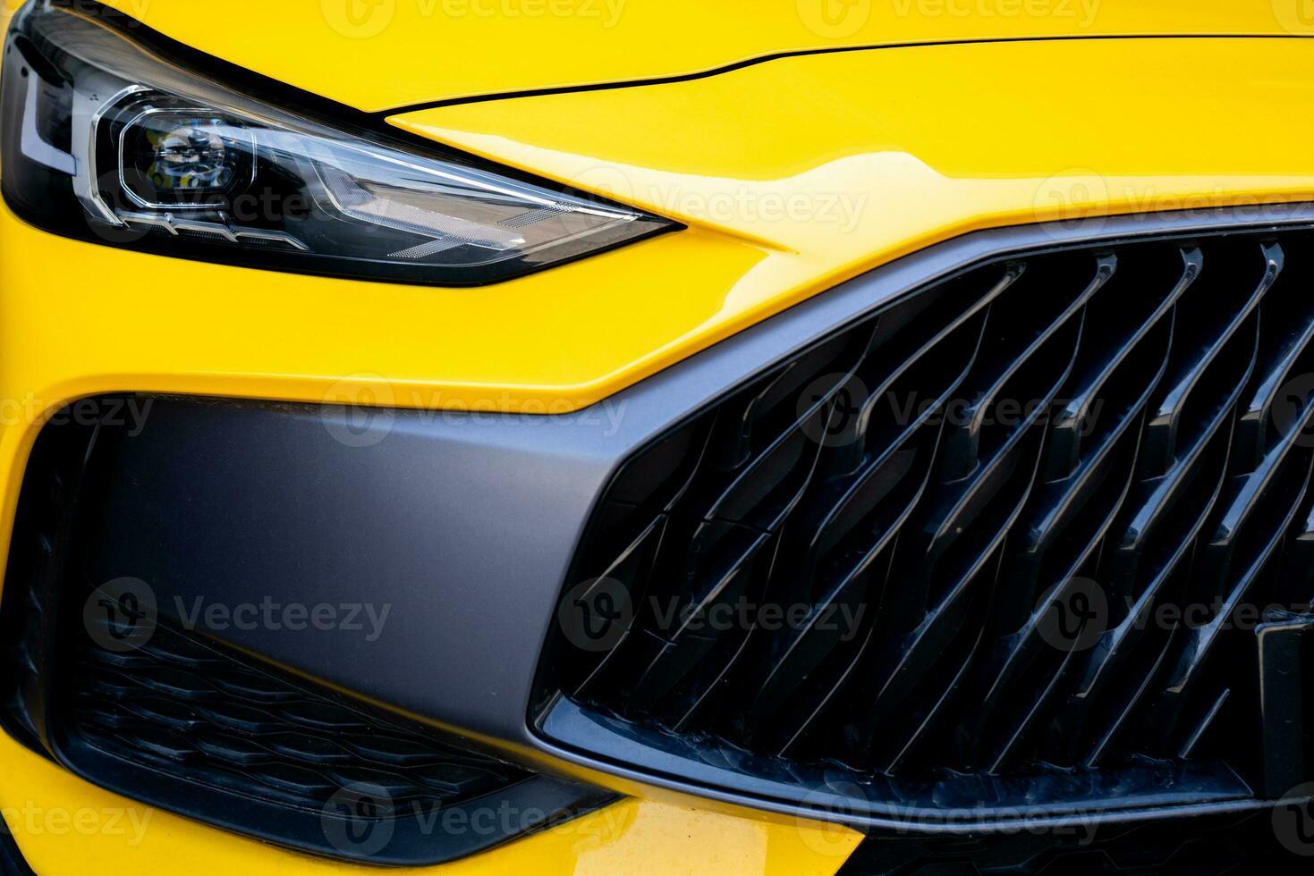 Closeup detail of yellow luxury car. Electric vehicle with modern technology. Expensive car. Shiny headlight of sport and modern design car. Automotive industry. Luxury car show at exhibition event. photo