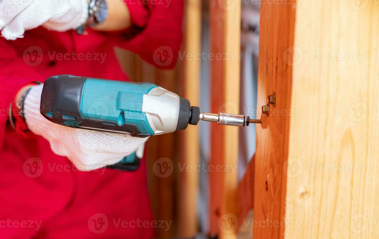 Carpenter and screwdriver hand tool. A skilled worker set to work drilling and installing wooden fixtures, using electric screwdriver to construct and repair parts of house with precision and care. photo