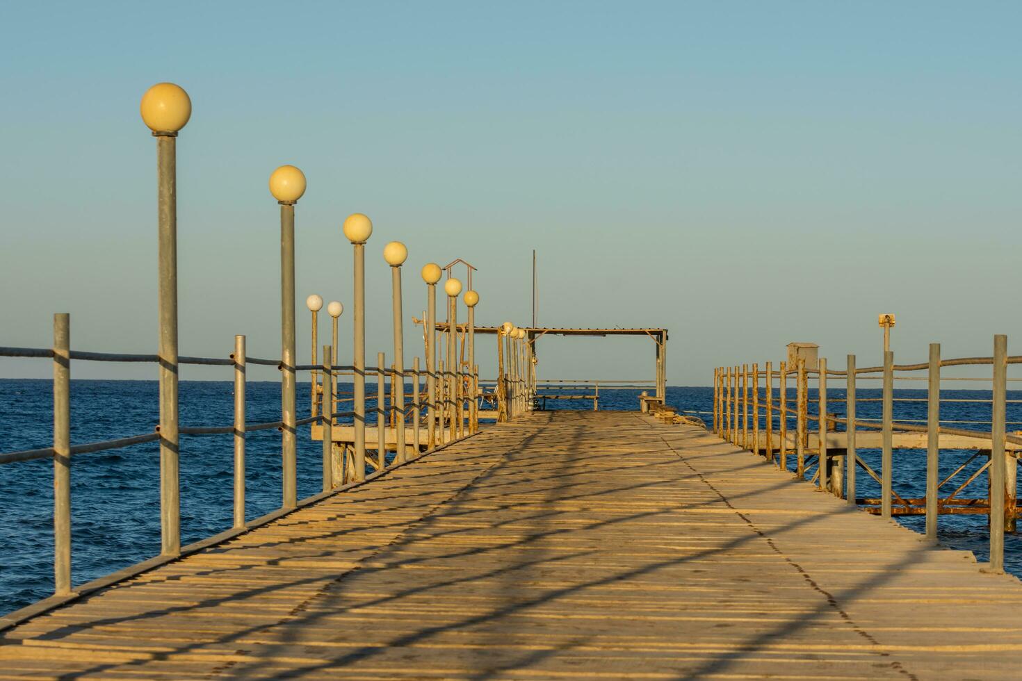 jetty with shadows in sun during the sunset at the beach photo