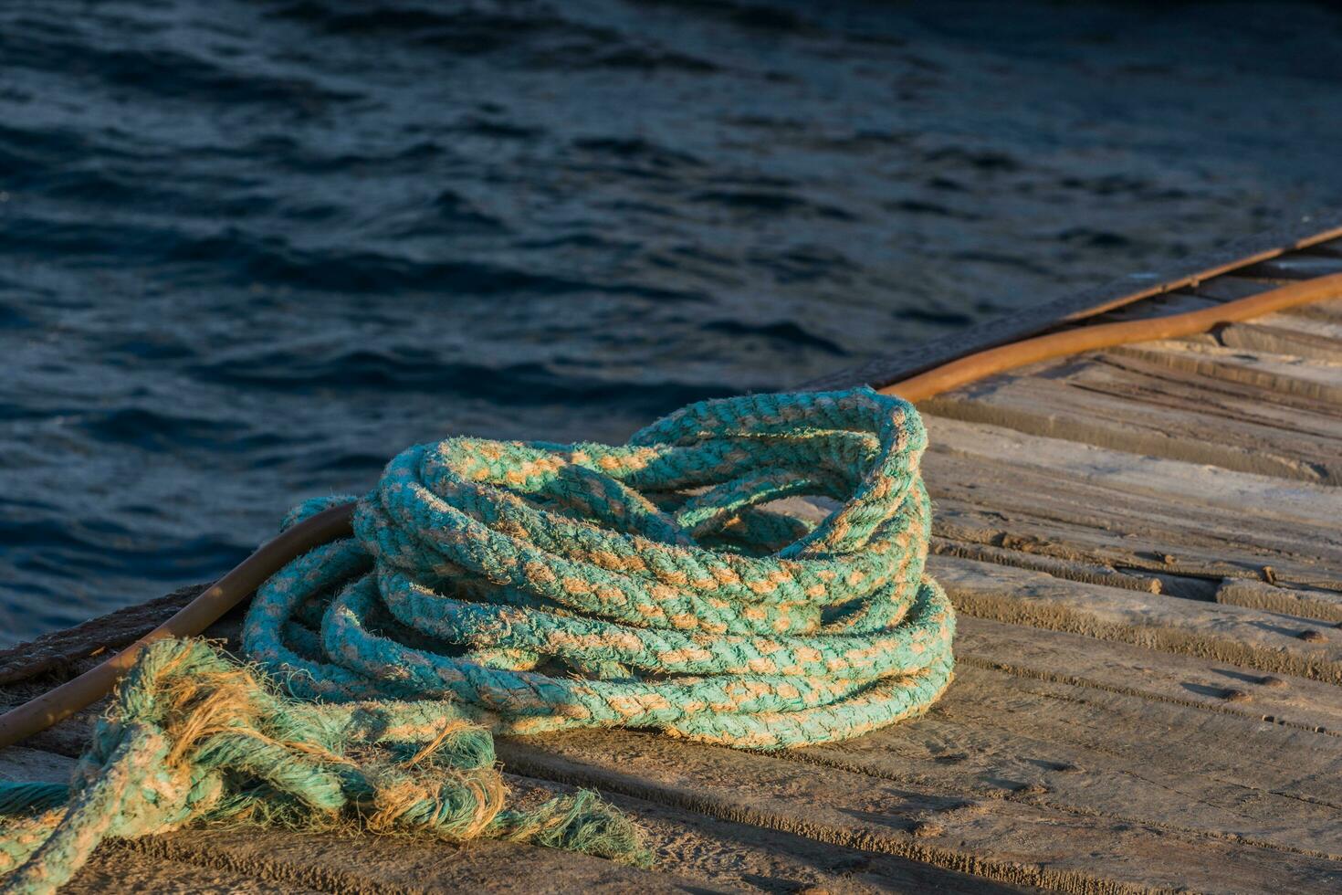 old colorful rope from a boat at a jetty on the sea photo