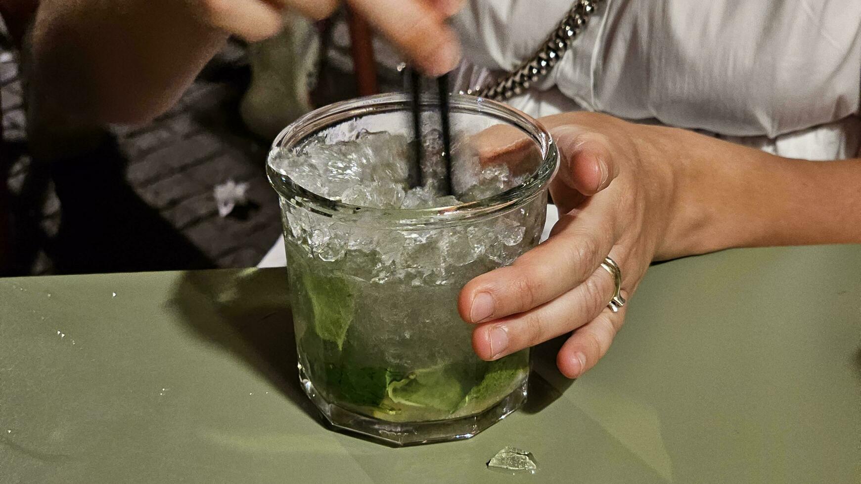 drinking a mojito cocktail with ice and lime on a summer evening in Spotorno, on the western Ligurian Riviera photo