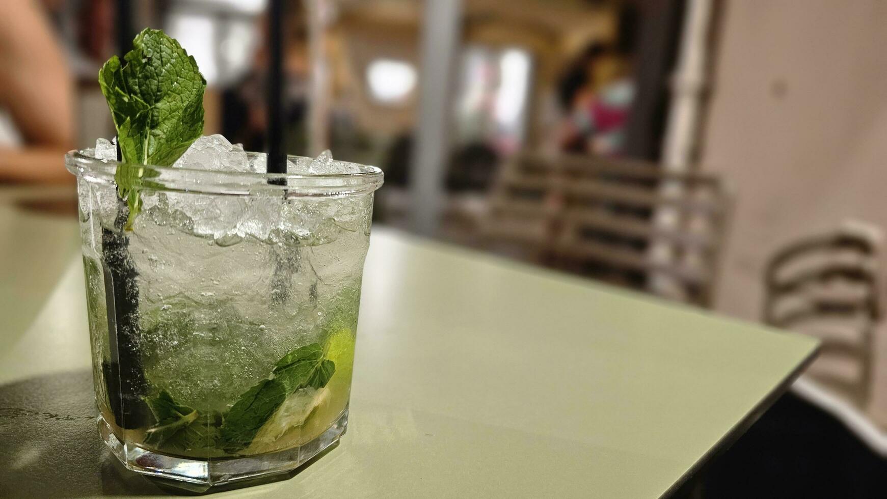 drinking a mojito cocktail with ice and lime on a summer evening in Spotorno, on the western Ligurian Riviera photo
