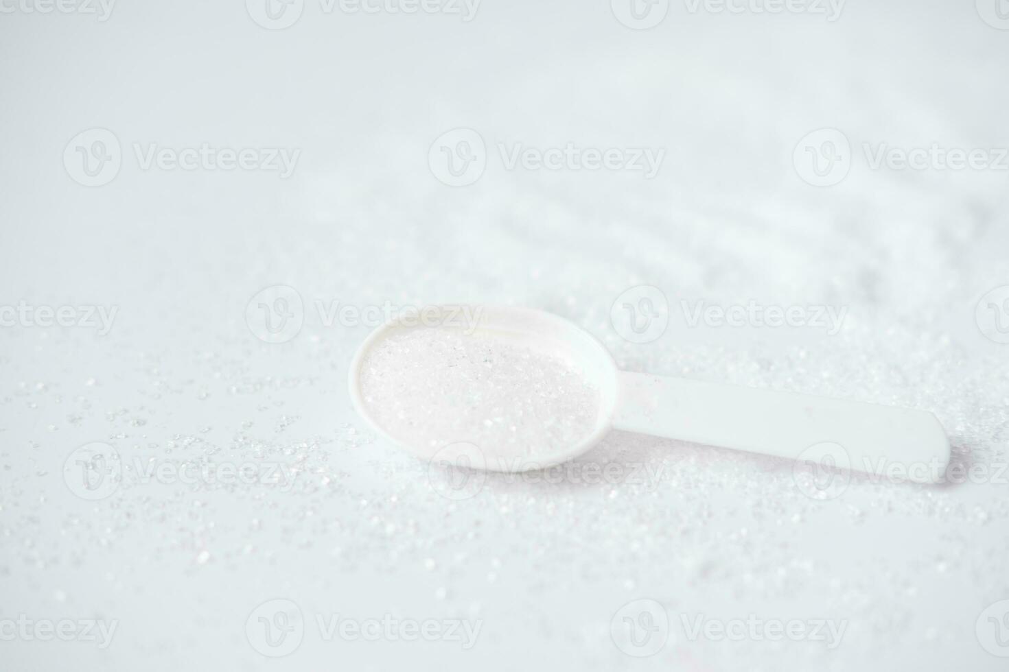 Epsom sales en un bañera medición cuchara en un blanco antecedentes. útil sal para relajación en el baño. magnesio sal foto