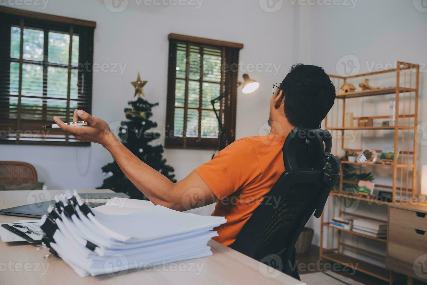 Satisfied caucasian successful guy, freelancer or ceo, relaxes at workplace with legs thrown on table. Stylish guy uses laptop, browses the Internet, looks for ideas for a project, sitting at the desk photo