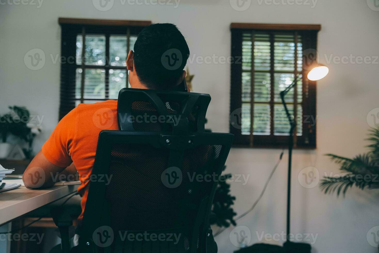 Satisfied caucasian successful guy, freelancer or ceo, relaxes at workplace with legs thrown on table. Stylish guy uses laptop, browses the Internet, looks for ideas for a project, sitting at the desk photo