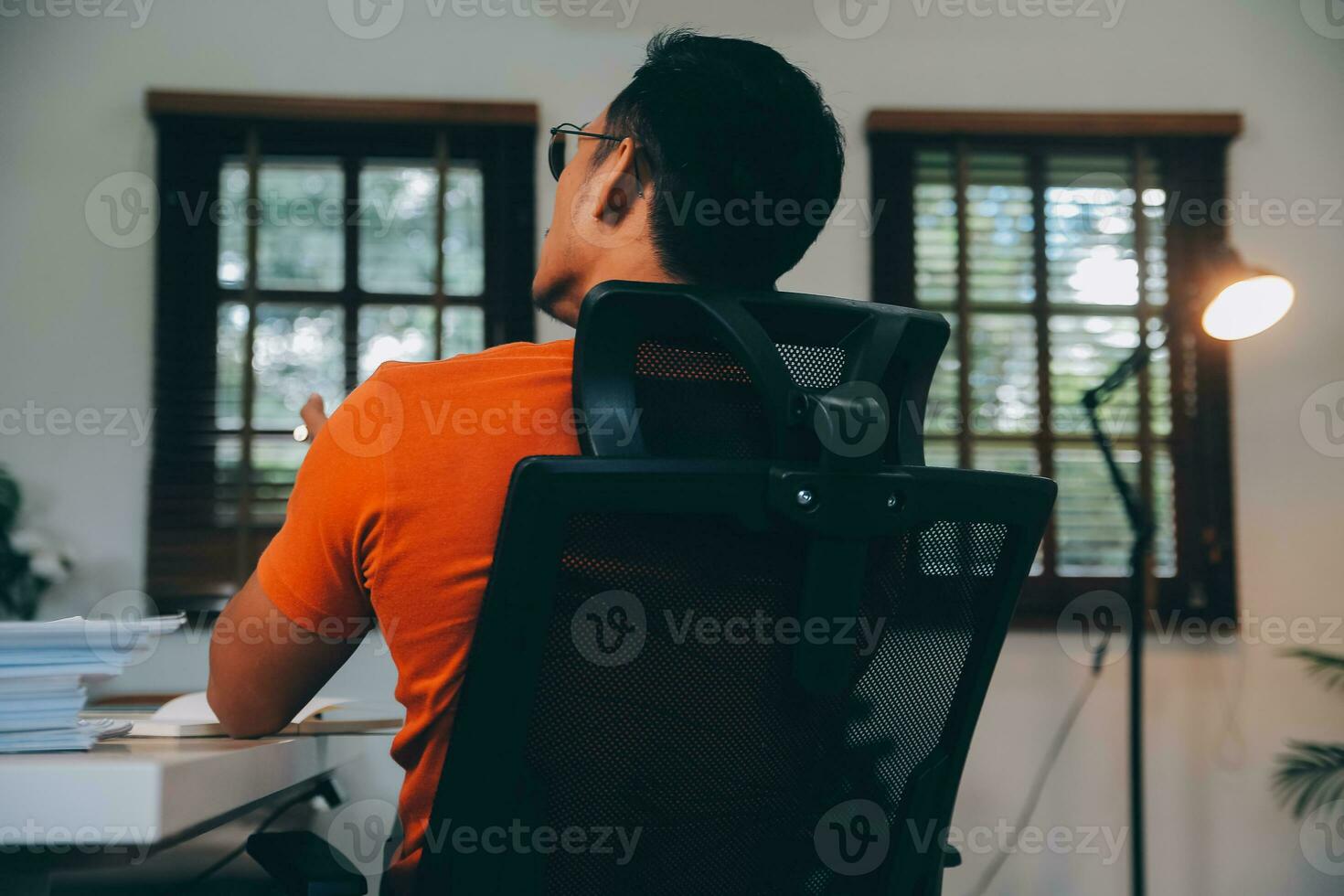 Satisfied caucasian successful guy, freelancer or ceo, relaxes at workplace with legs thrown on table. Stylish guy uses laptop, browses the Internet, looks for ideas for a project, sitting at the desk photo
