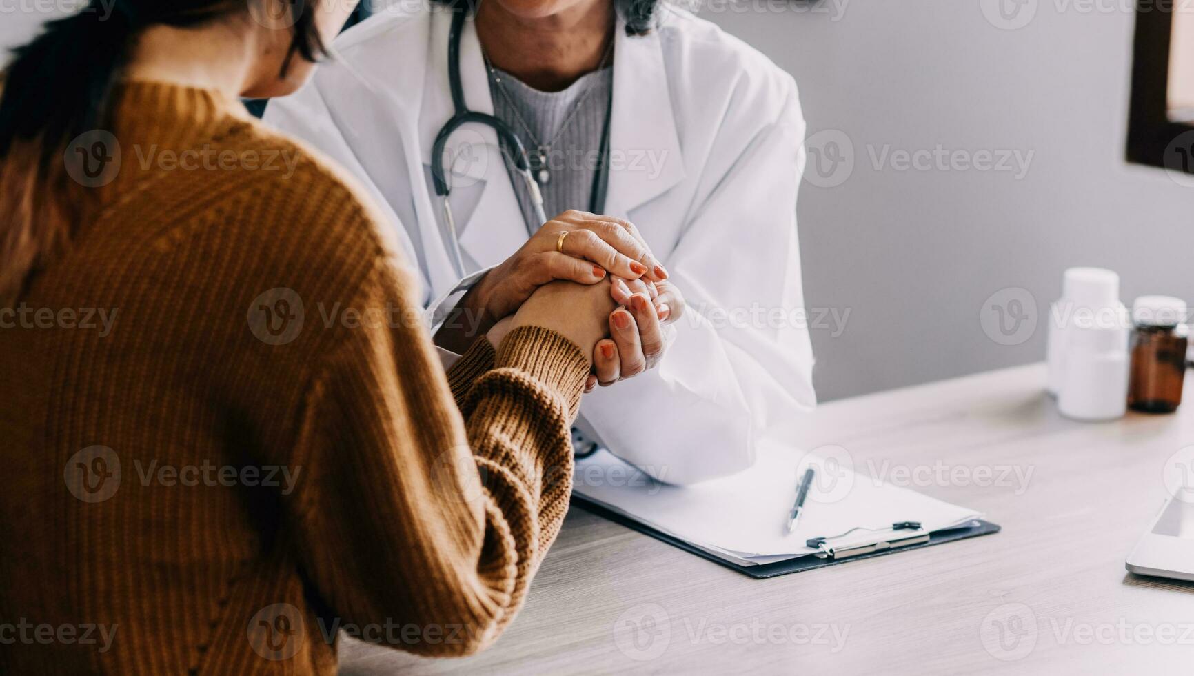 Young psychologist holding hand of her patient in need while consulting her after discussion of problem photo