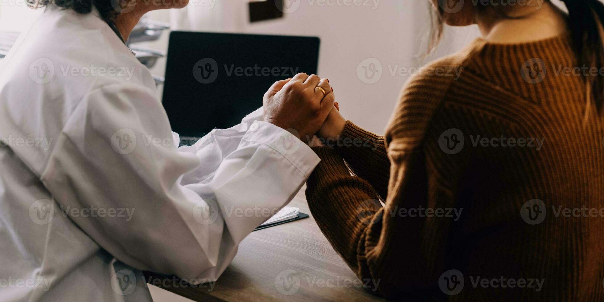 Young psychologist holding hand of her patient in need while consulting her after discussion of problem photo