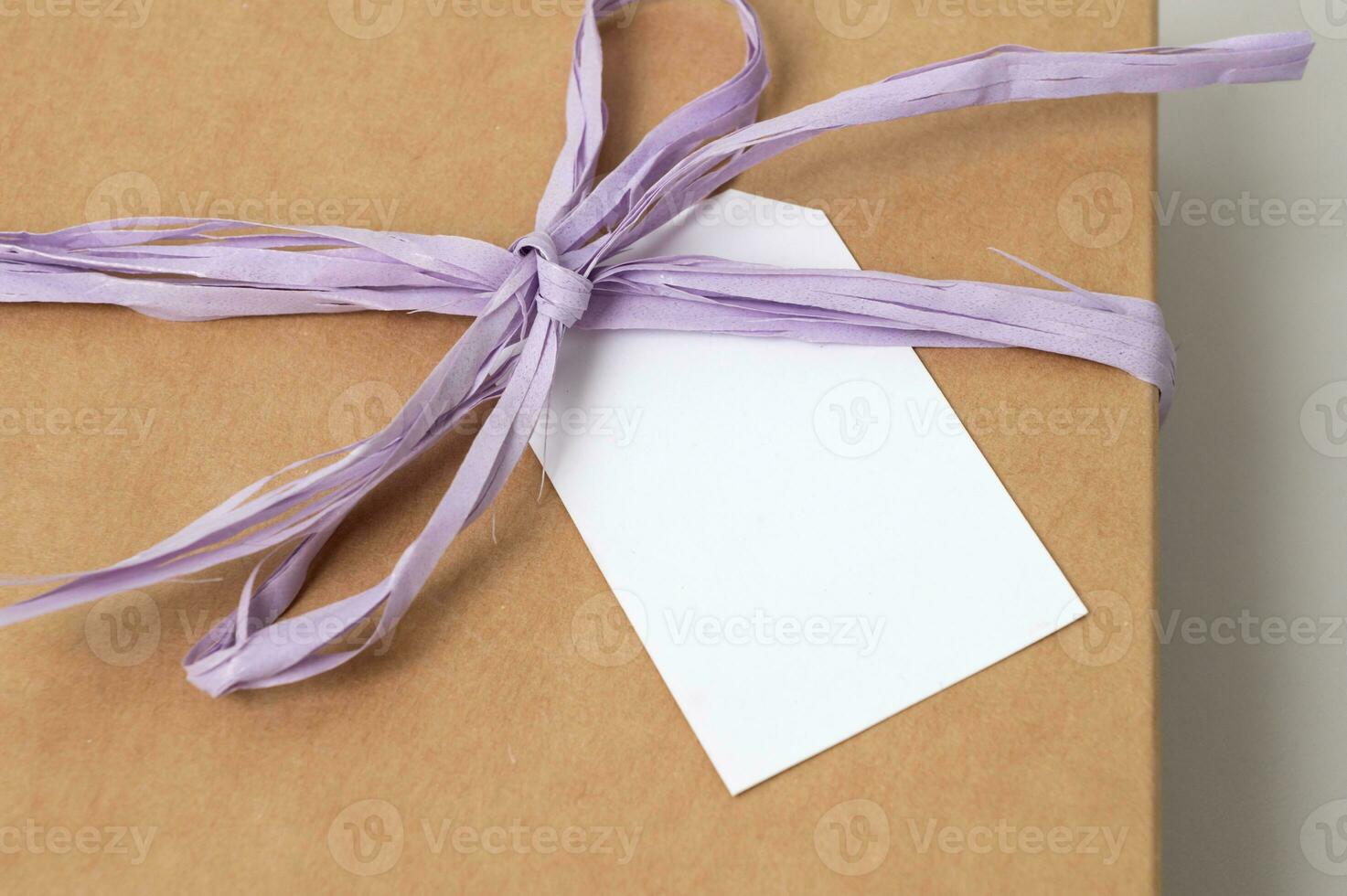 Mockup of a tag on a brown craft box with a ribbon. Space for text, copy space photo