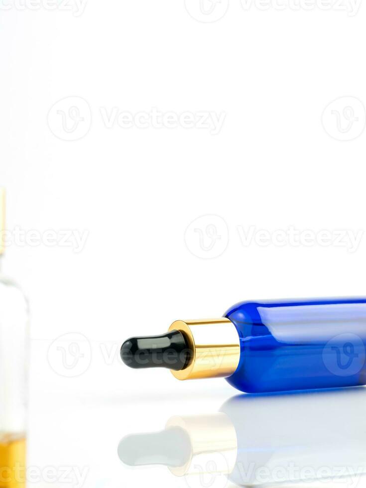 Blue glass cosmetic bottle with a dropper on a white background. Natural cosmetics concept, natural essential oil and skin care products. Copy space photo