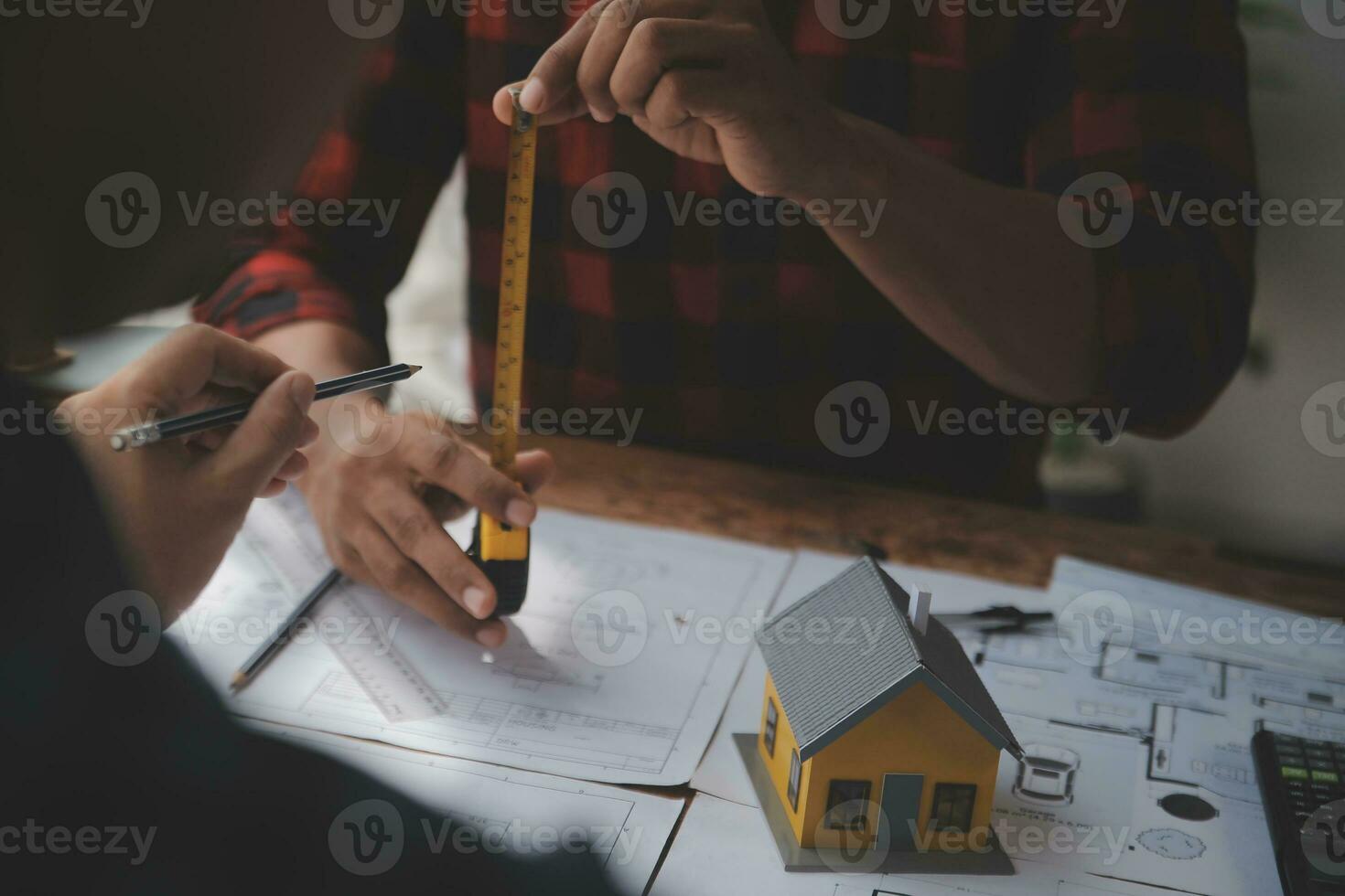 Close up of civil male engineer asian working on blueprint architectural project at construction site at desk in office. photo