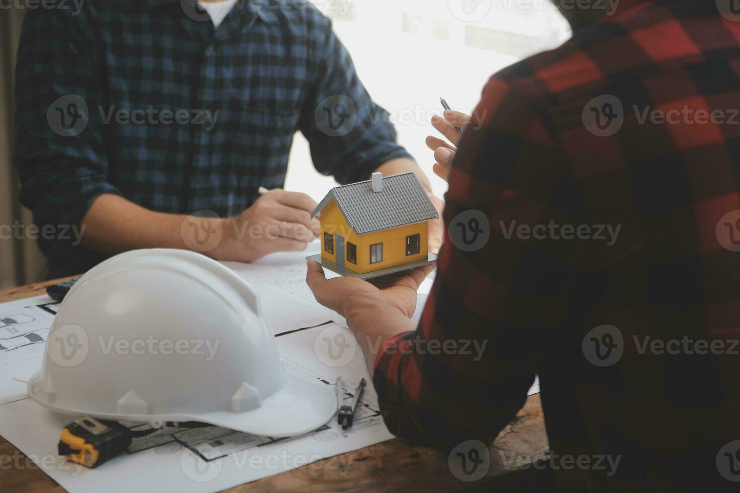 Close up of civil male engineer asian working on blueprint architectural project at construction site at desk in office. photo