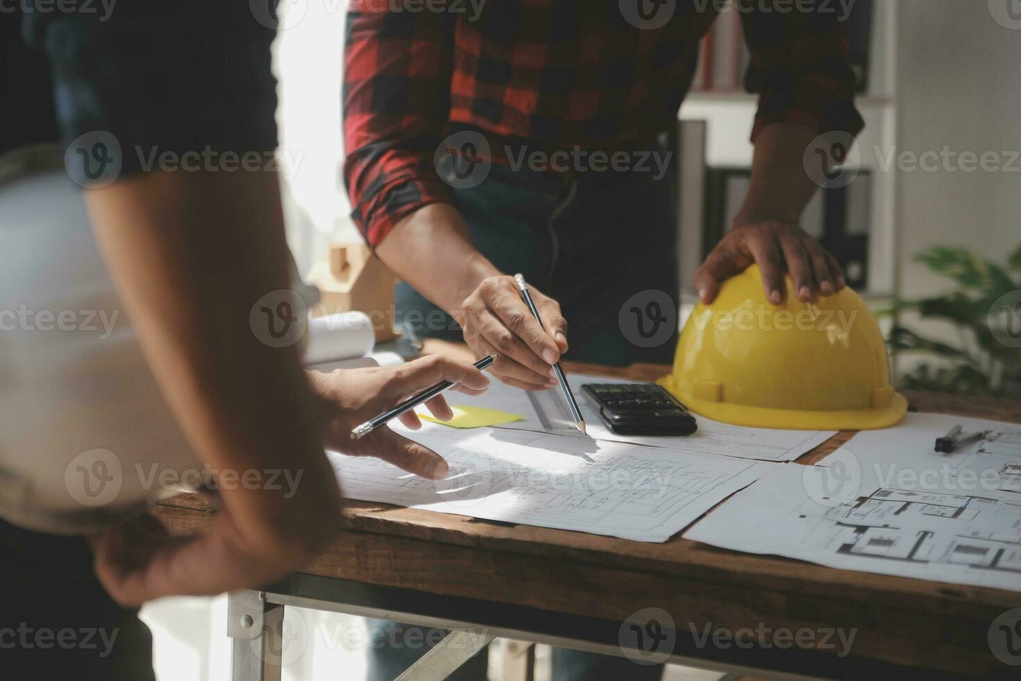 Close up of civil male engineer asian working on blueprint architectural project at construction site at desk in office. photo