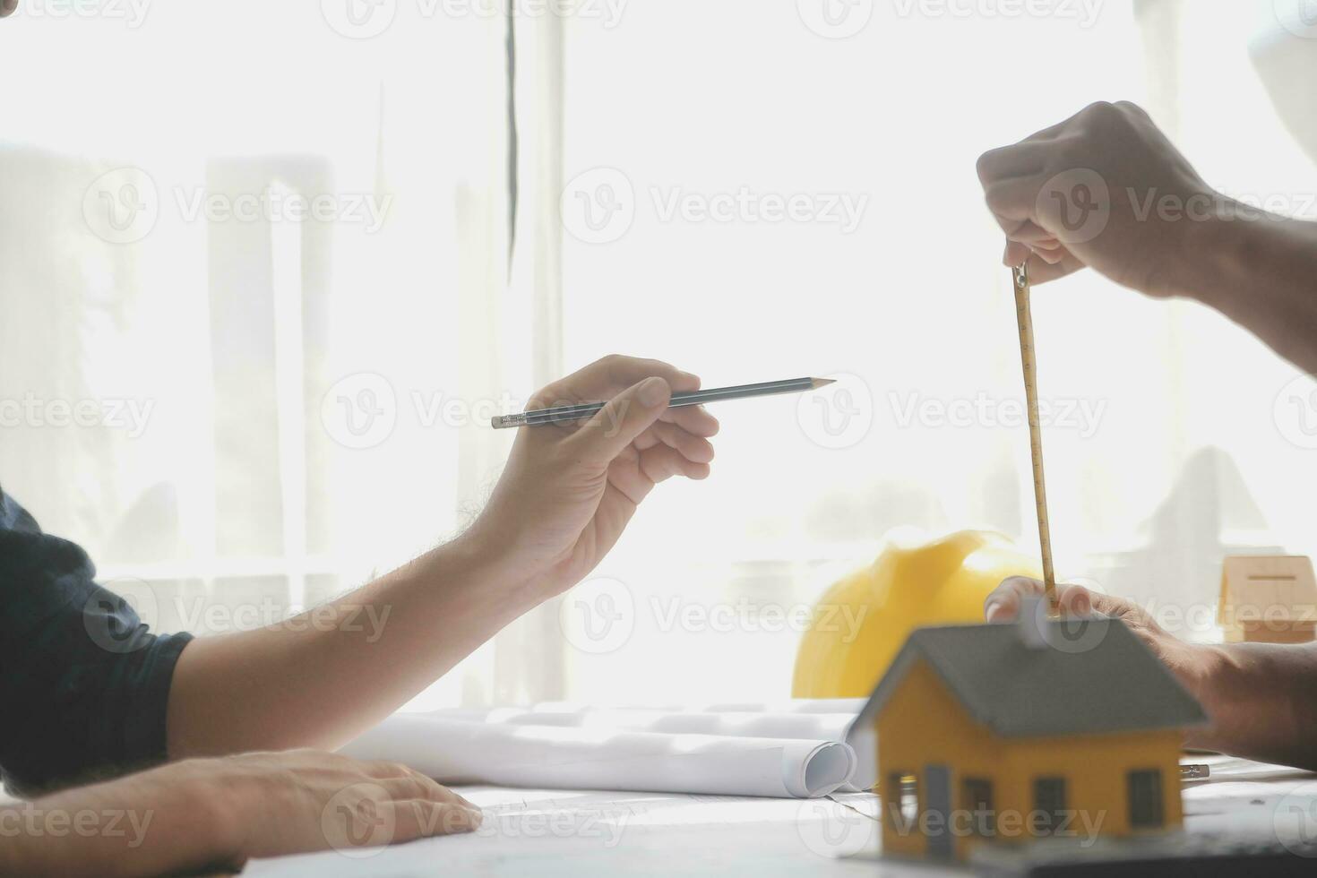 Close up of civil male engineer asian working on blueprint architectural project at construction site at desk in office. photo