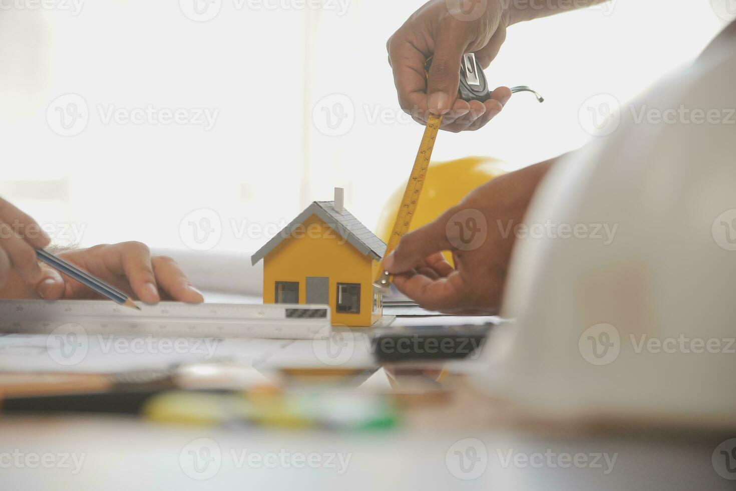 Close up of civil male engineer asian working on blueprint architectural project at construction site at desk in office. photo