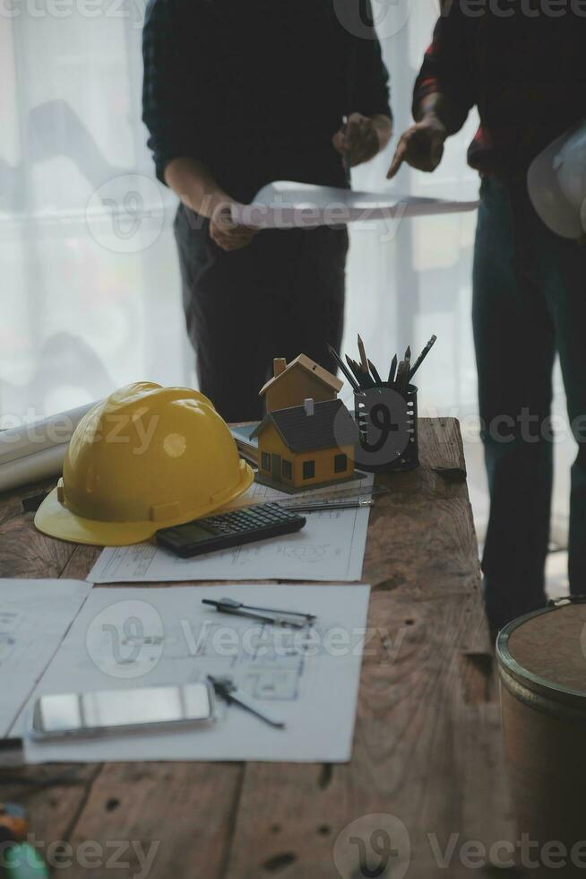 Close up of civil male engineer asian working on blueprint architectural project at construction site at desk in office. photo