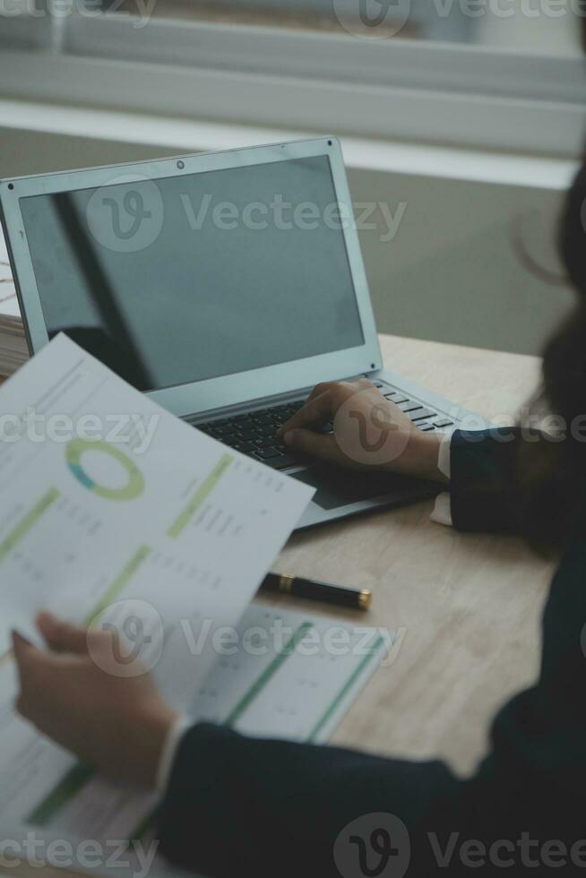 Close up Business woman using calculator and laptop for do math finance on wooden desk, tax, accounting, statistics and analytical research concept photo
