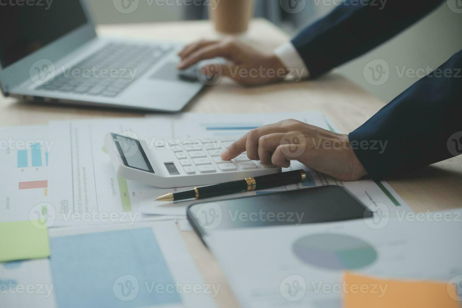 Close up Business woman using calculator and laptop for do math finance on wooden desk, tax, accounting, statistics and analytical research concept photo