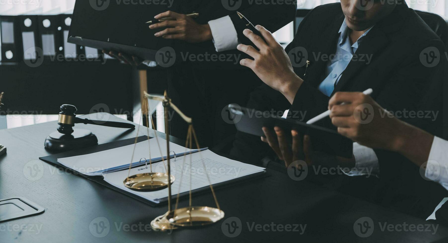 Business and lawyers discussing contract papers with brass scale on desk in office. Law, legal services, advice, justice and law concept picture with film grain effect photo