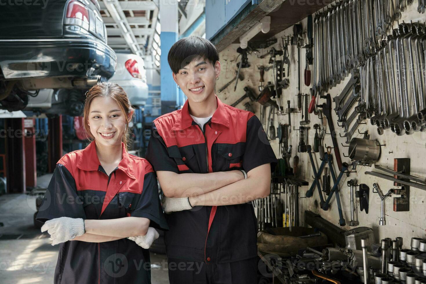 retrato de dos profesional asiático mecánico socios sonrisa y brazos cruzado con mano herramientas maquinaria, fijación trabajo a coche Servicio cochera, mantenimiento y reparar trabajos en automotor industria negocio. foto