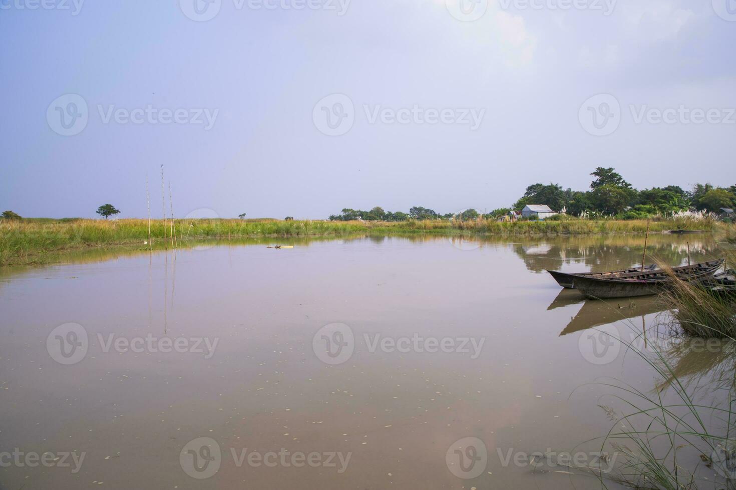 Canal with green grass and vegetation reflected in the water near Padma River in Bangladesh photo