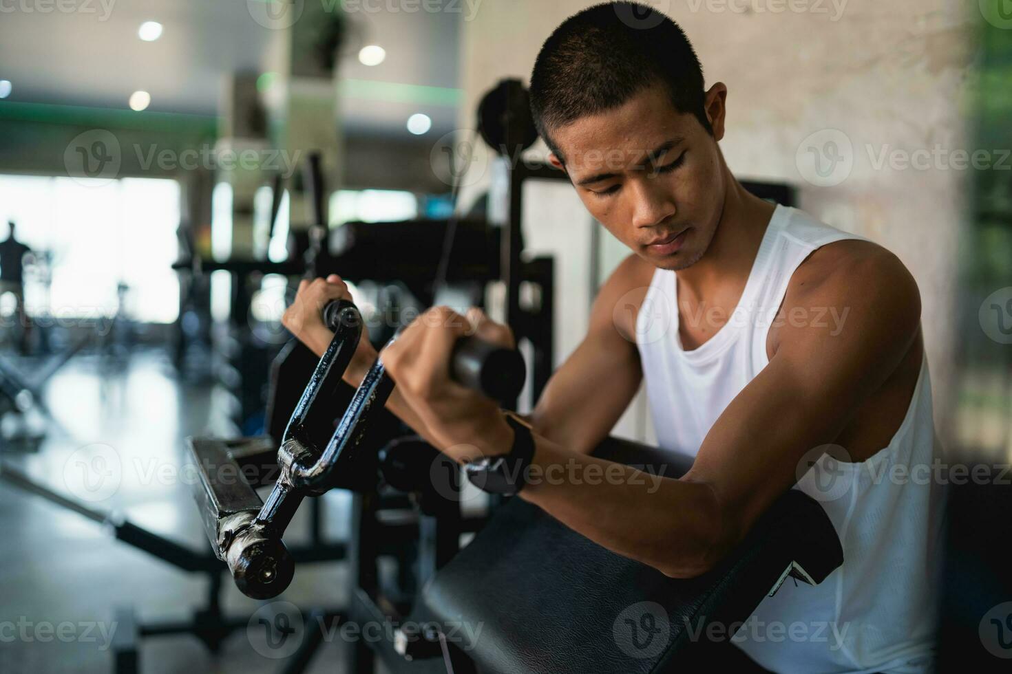 Asian sport man using dumbbell exercise at gym. Asian body building for muscle training. Sport health gym concept. photo