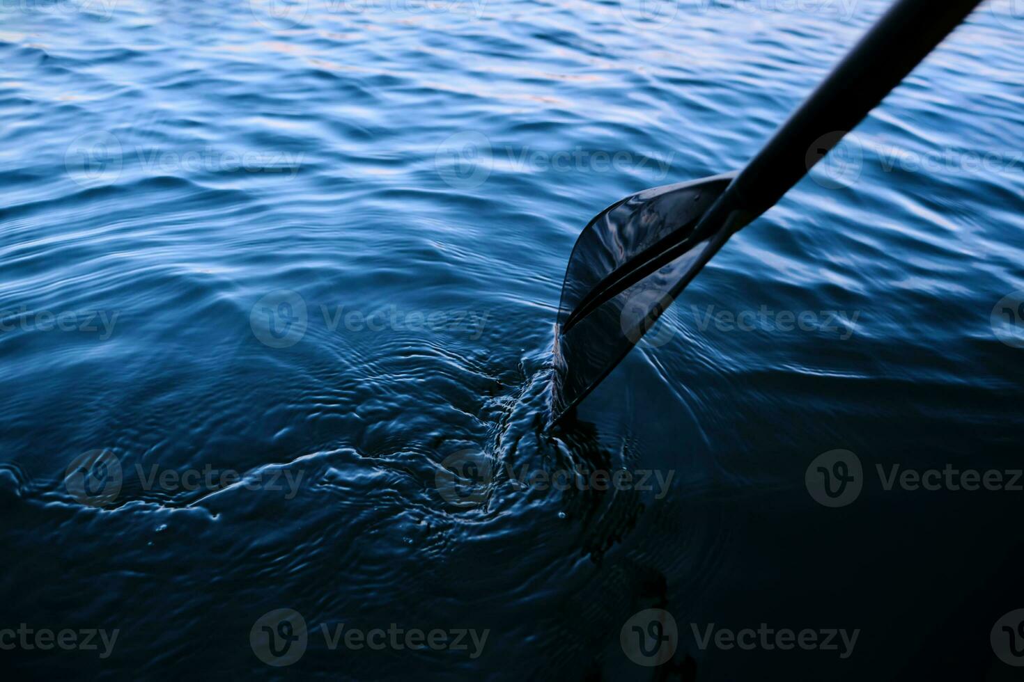 Close-up of an oar against the water. photo