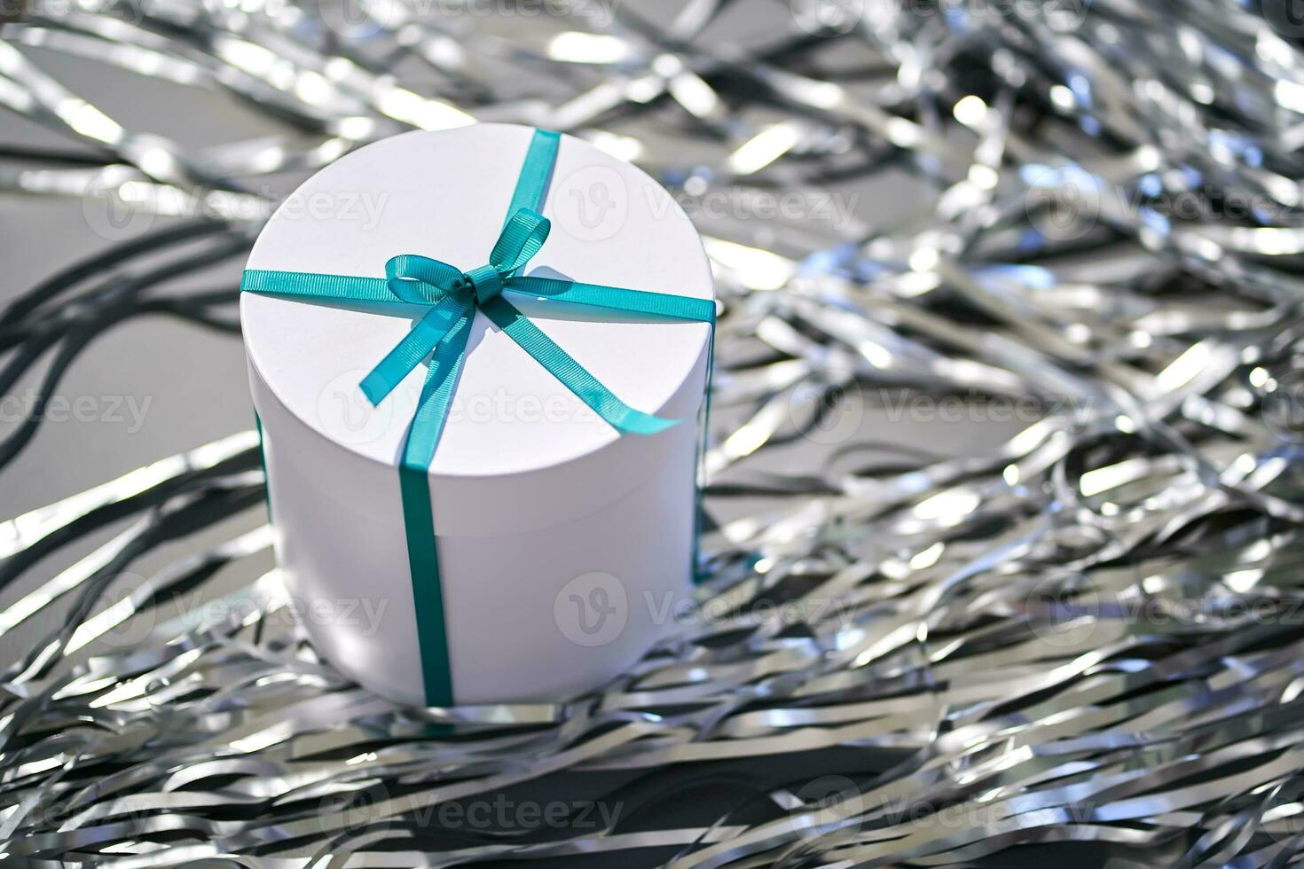 White box with a gift in tinsel. photo