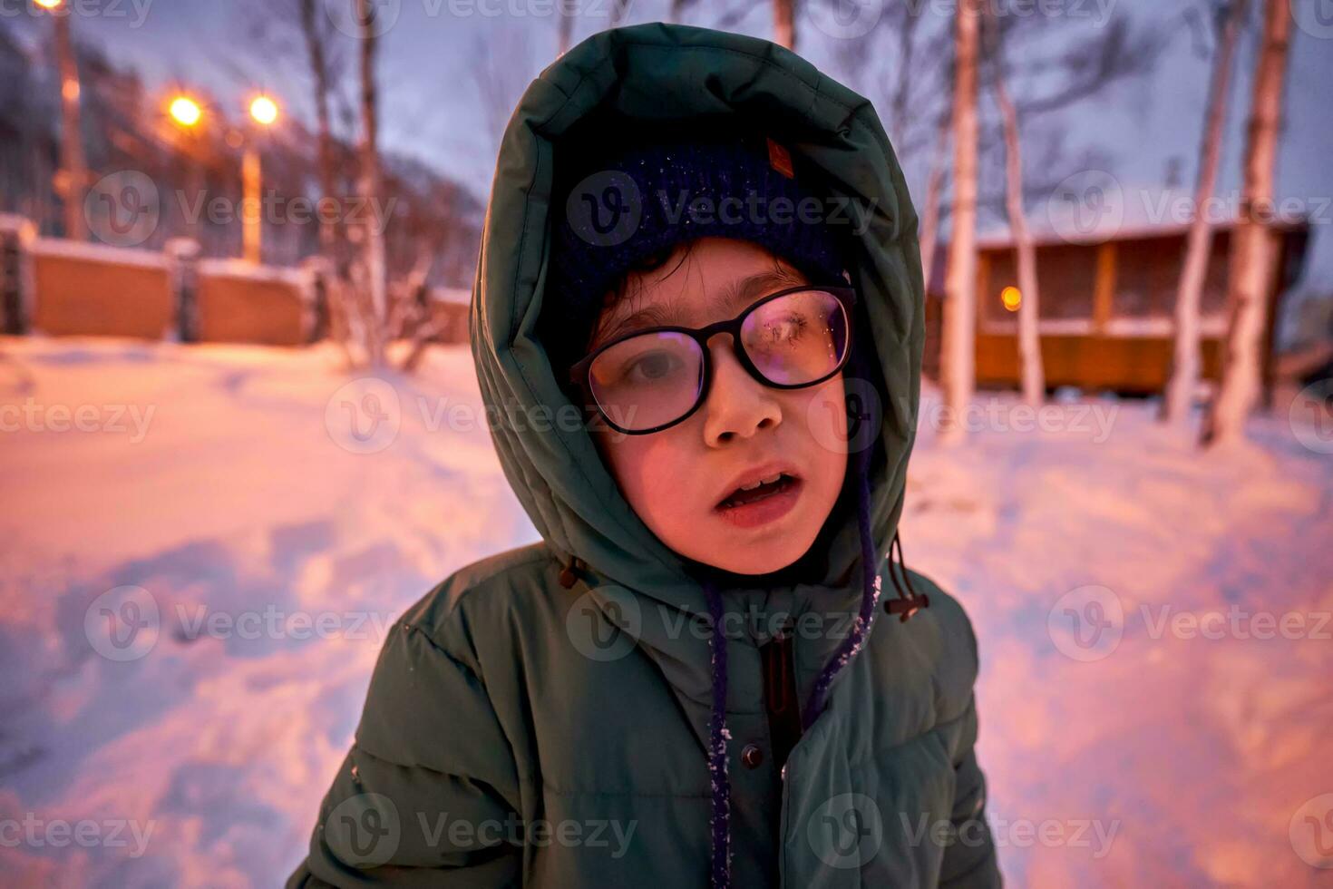 un chico en invierno ropa y empañado lentes. foto