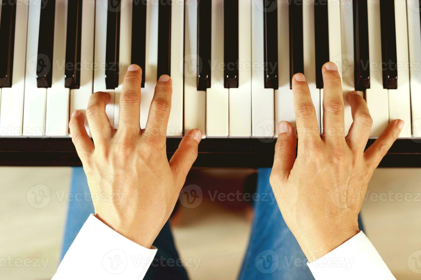 close up of hand people man musician playing piano keyboard with selective focus keys. can be used as a background. photo