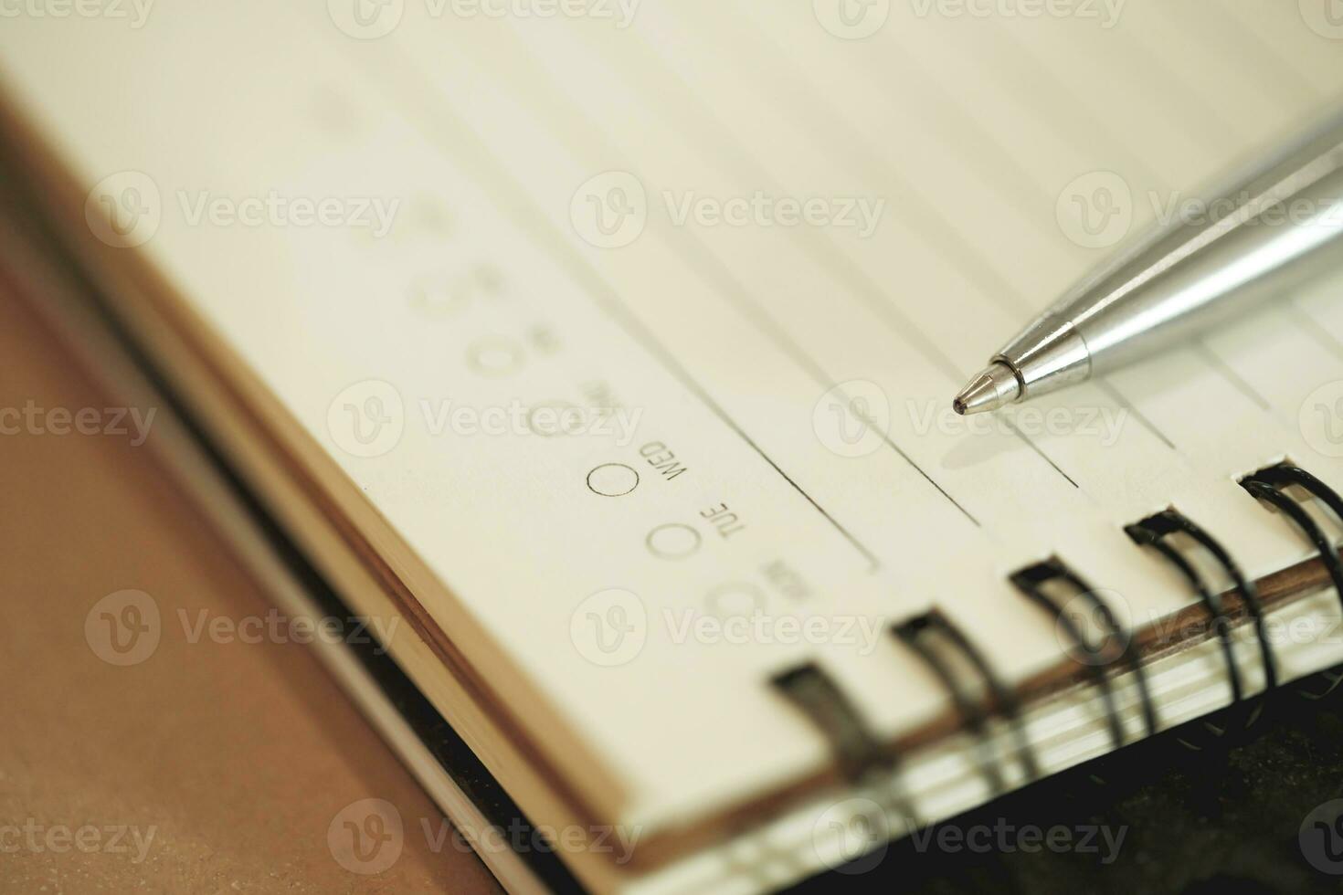 sketch notepad and a pen on wooden background with copy space. top view blank notebook and text. photo