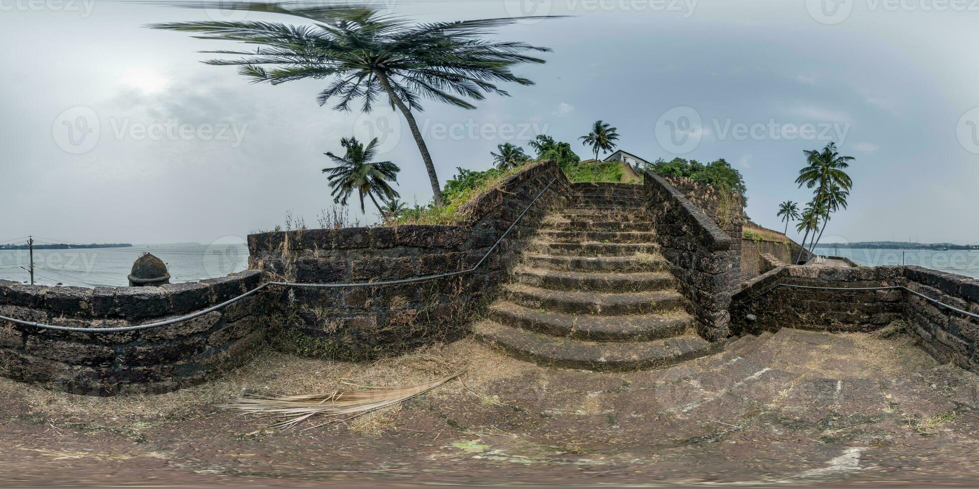 full hdri 360 panorama portuguese defensive abandoned military fortress with stone staircase on ocean with palm trees in equirectangular projection with zenith and nadir. VR AR content photo
