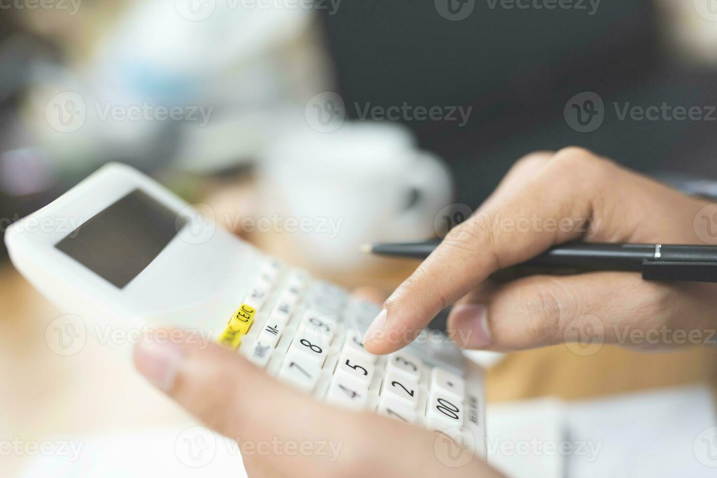 Unrecognizable businessman using calculator photo