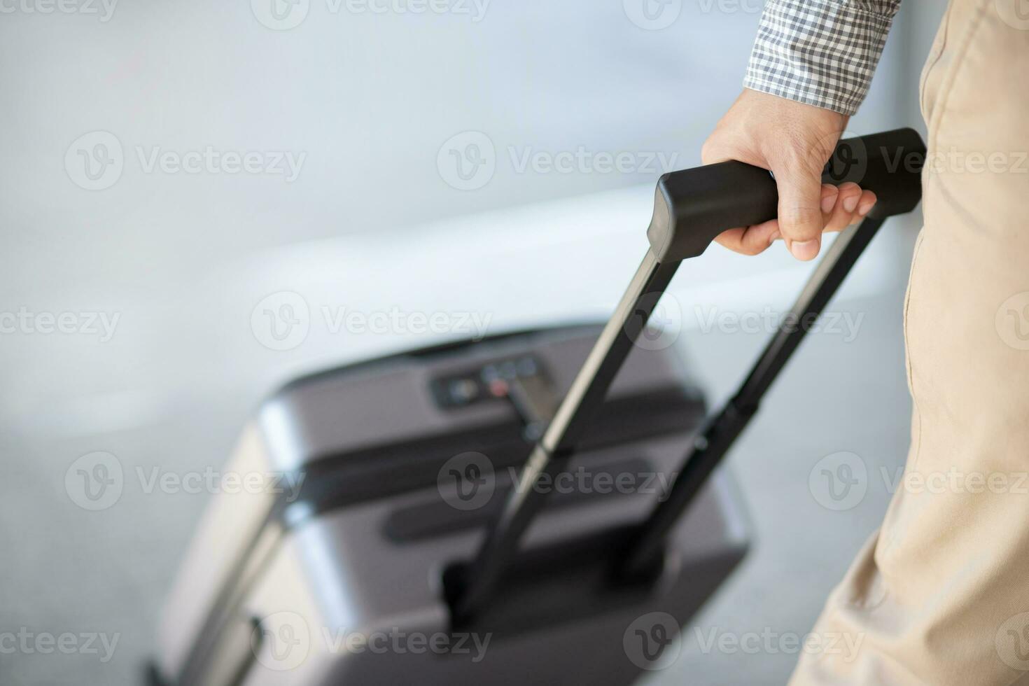 business man walking outside public transport building with luggage in rush hour. Business traveler pulling suitcase in modern airport terminal. baggage business Trip. photo
