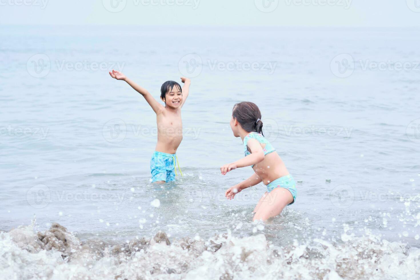 A boy and a girl are having fun playing in the sea. photo