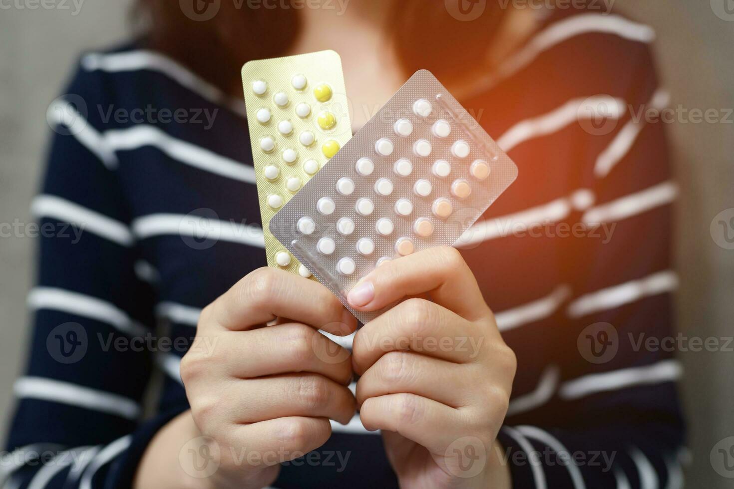 Woman hands opening birth control pills in hand. Eating Contraceptive Pill. photo