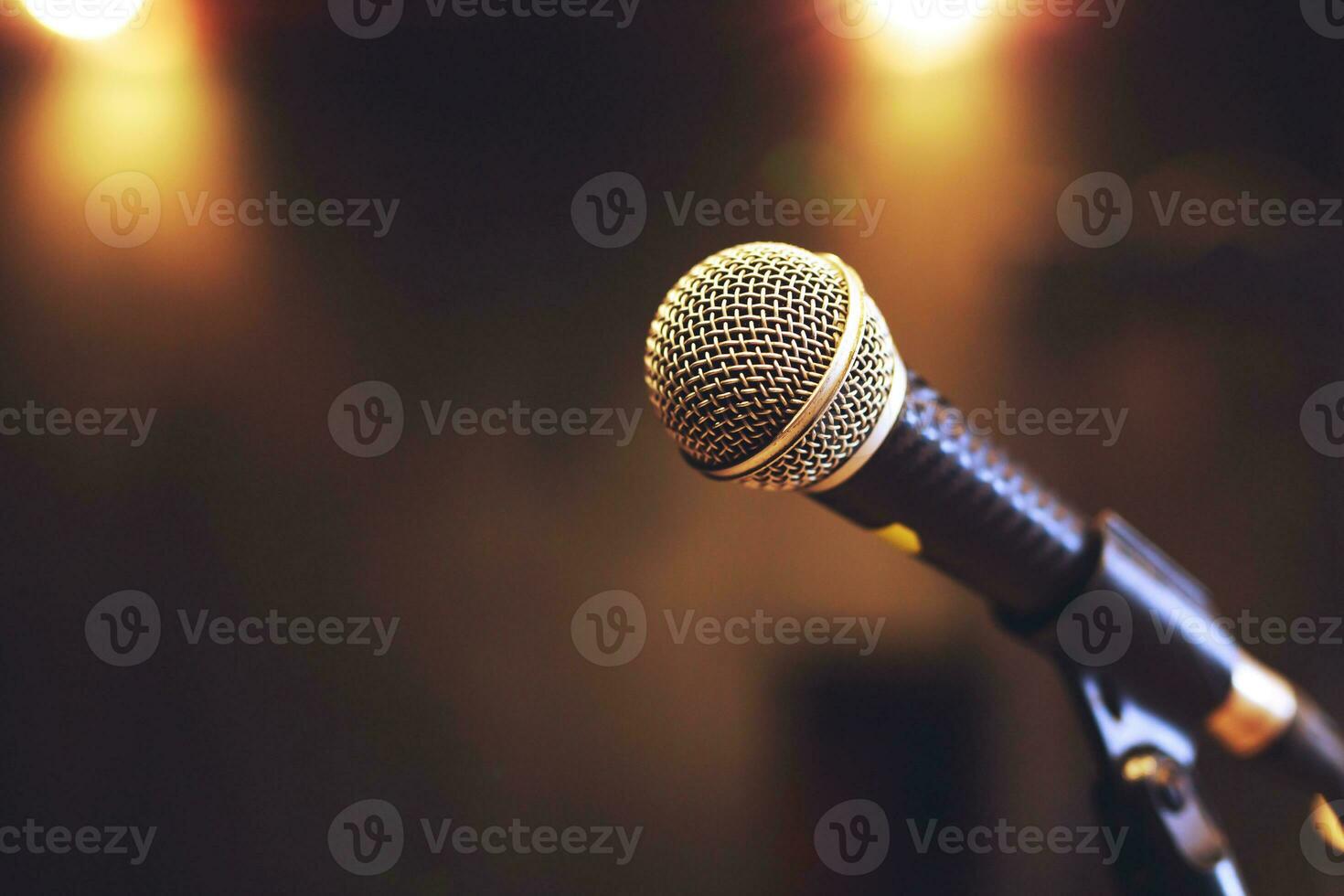 Close up of microphone on stage lighting at concert hall or conference room. copy space banner. soft focus. photo
