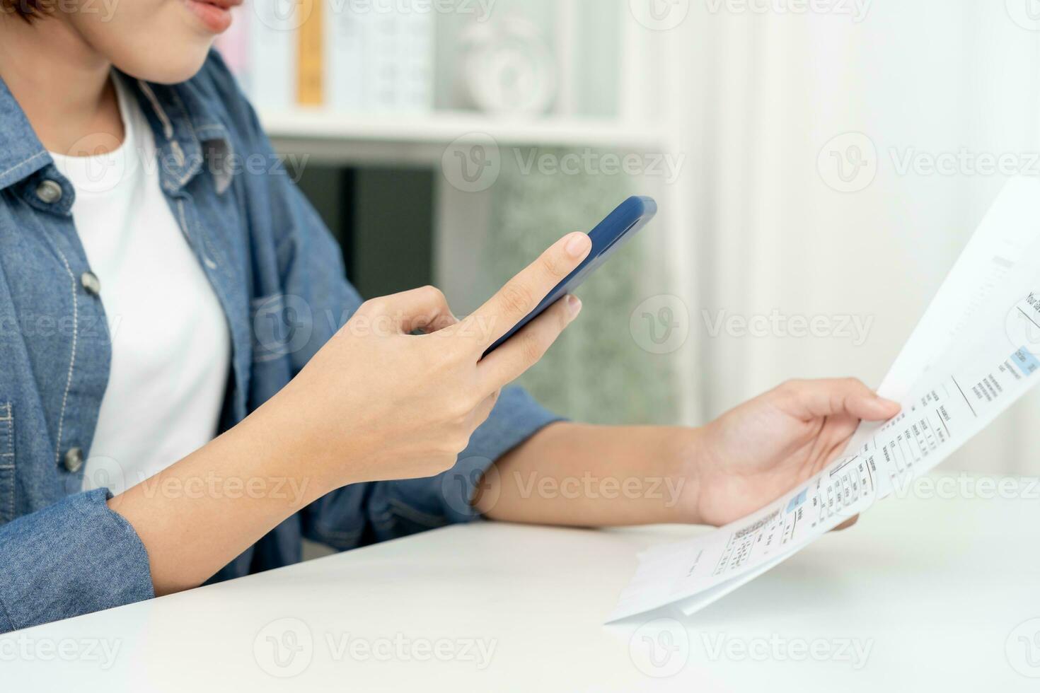 woman use phone scan barcode or QR codes to pay credit card bill after receiving document invoice. payment, receive, paying electricity, digital payments, technology, scanning, financial transactions photo