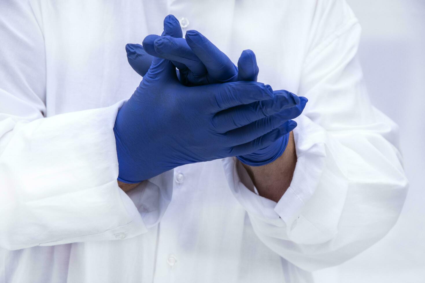 Strong hands of a doctor in blue sterile gloves close-up. Blue Nitrile gloves. Hands macro shot. photo