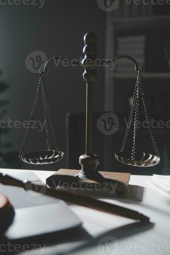 Business and lawyers discussing contract papers with brass scale on desk in office. Law, legal services, advice, justice and law concept picture with film grain effect photo