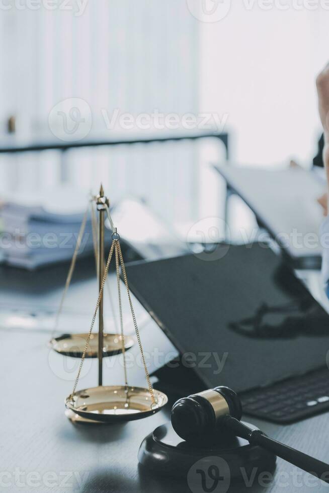 Business and lawyers discussing contract papers with brass scale on desk in office. Law, legal services, advice, justice and law concept picture with film grain effect photo