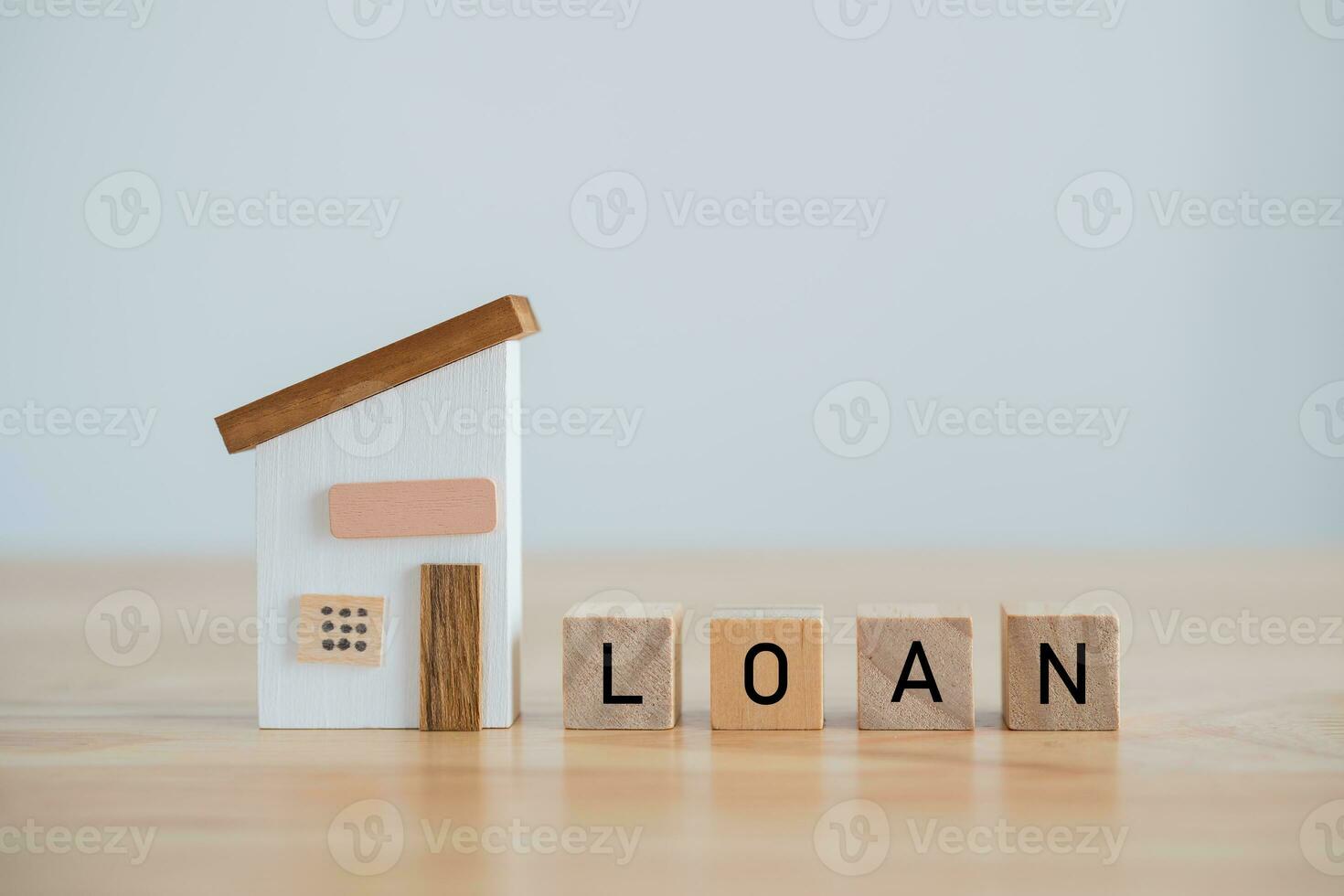 Model house and wood blocks with word LOAN on table. plan finances investments and savings to buy house real estate.Money coin and home on table business accounting and tax and insurance concept. photo