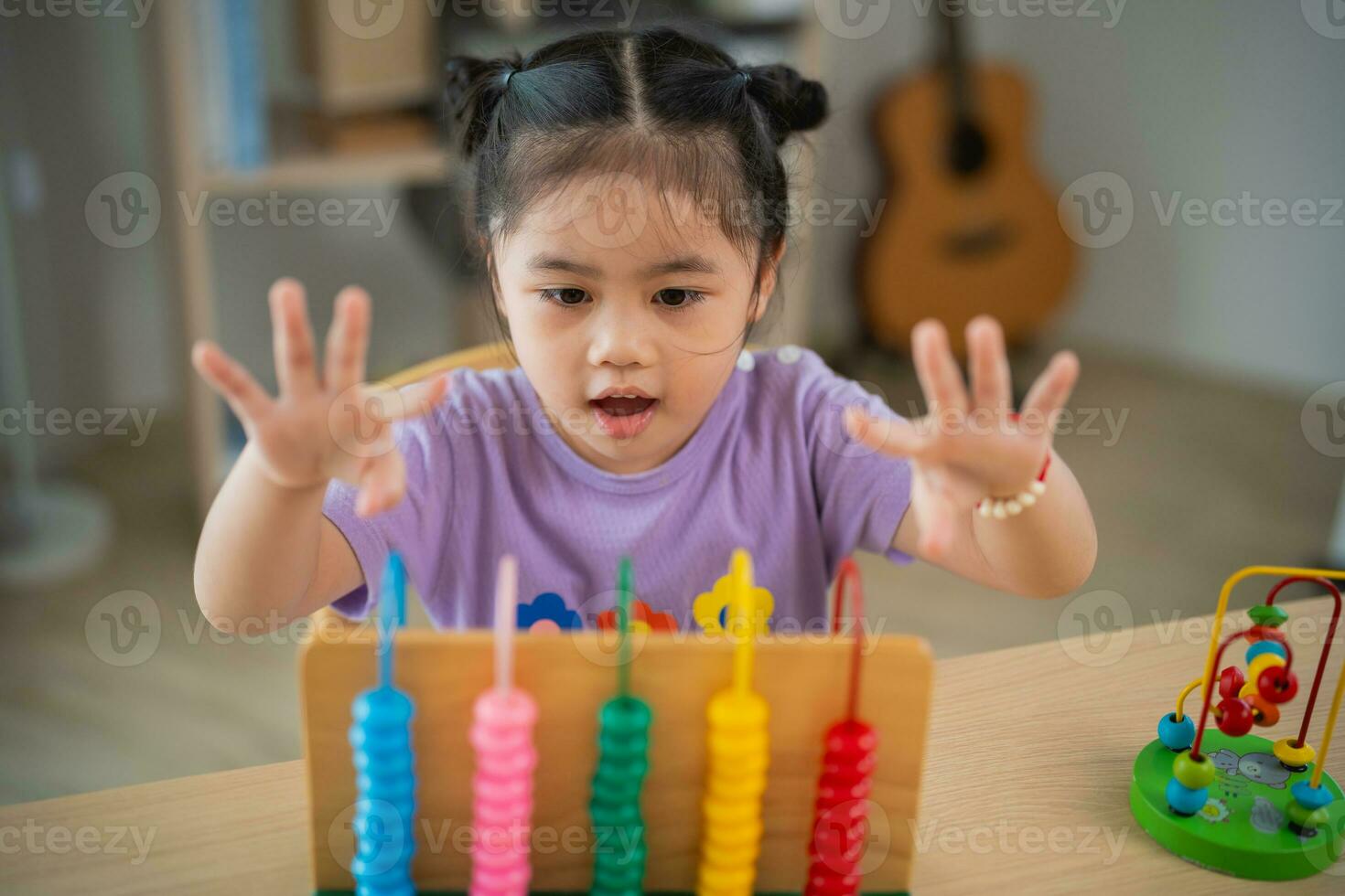 joven linda asiático bebé niña es aprendizaje el ábaco con de colores rosario a aprender cómo a contar en el mesa en el vivo habitación a hogar. niño bebé niña desarrollo estudiando concepto. foto