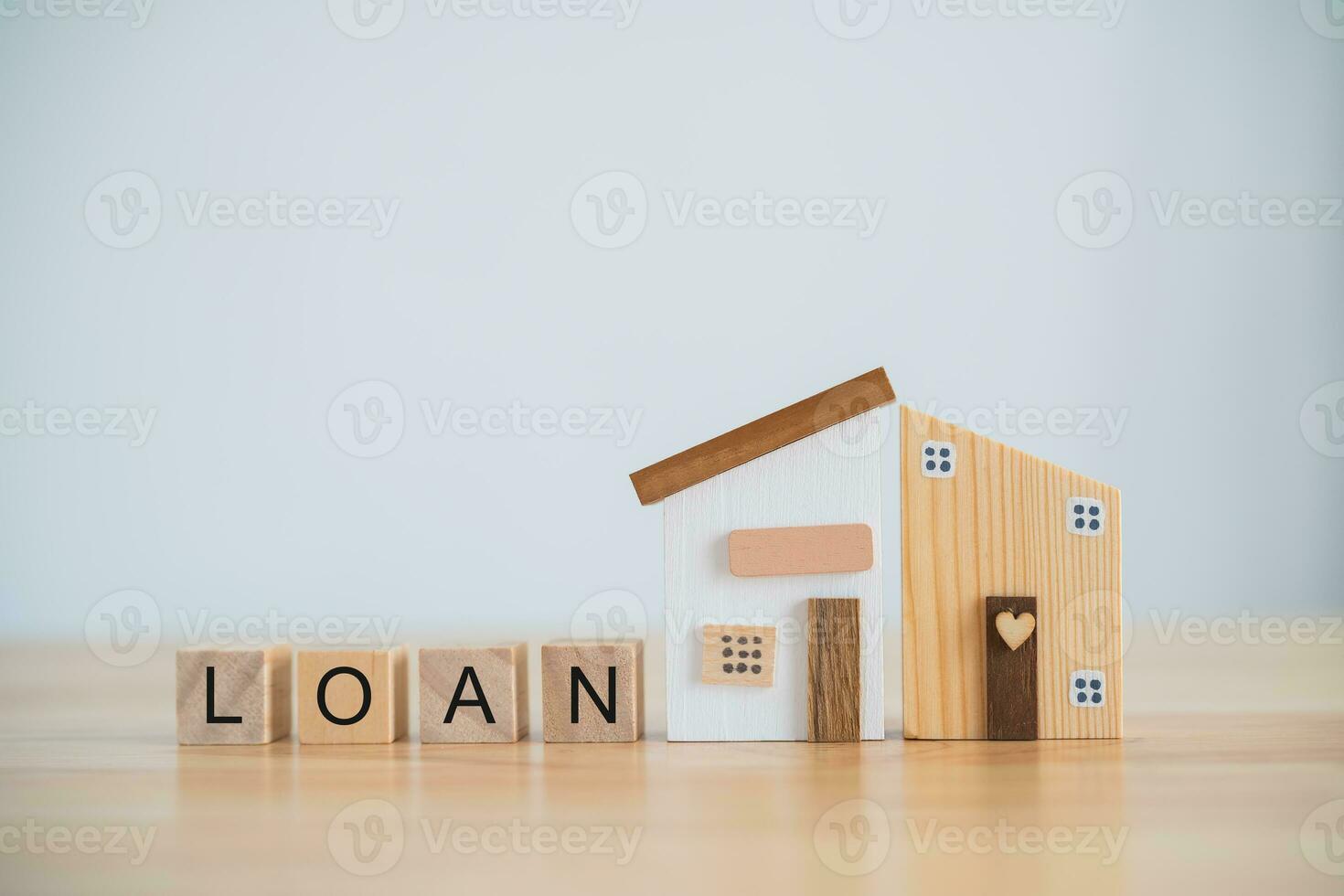 Model house and wood blocks with word LOAN on table. plan finances investments and savings to buy house real estate.Money coin and home on table business accounting and tax and insurance concept. photo