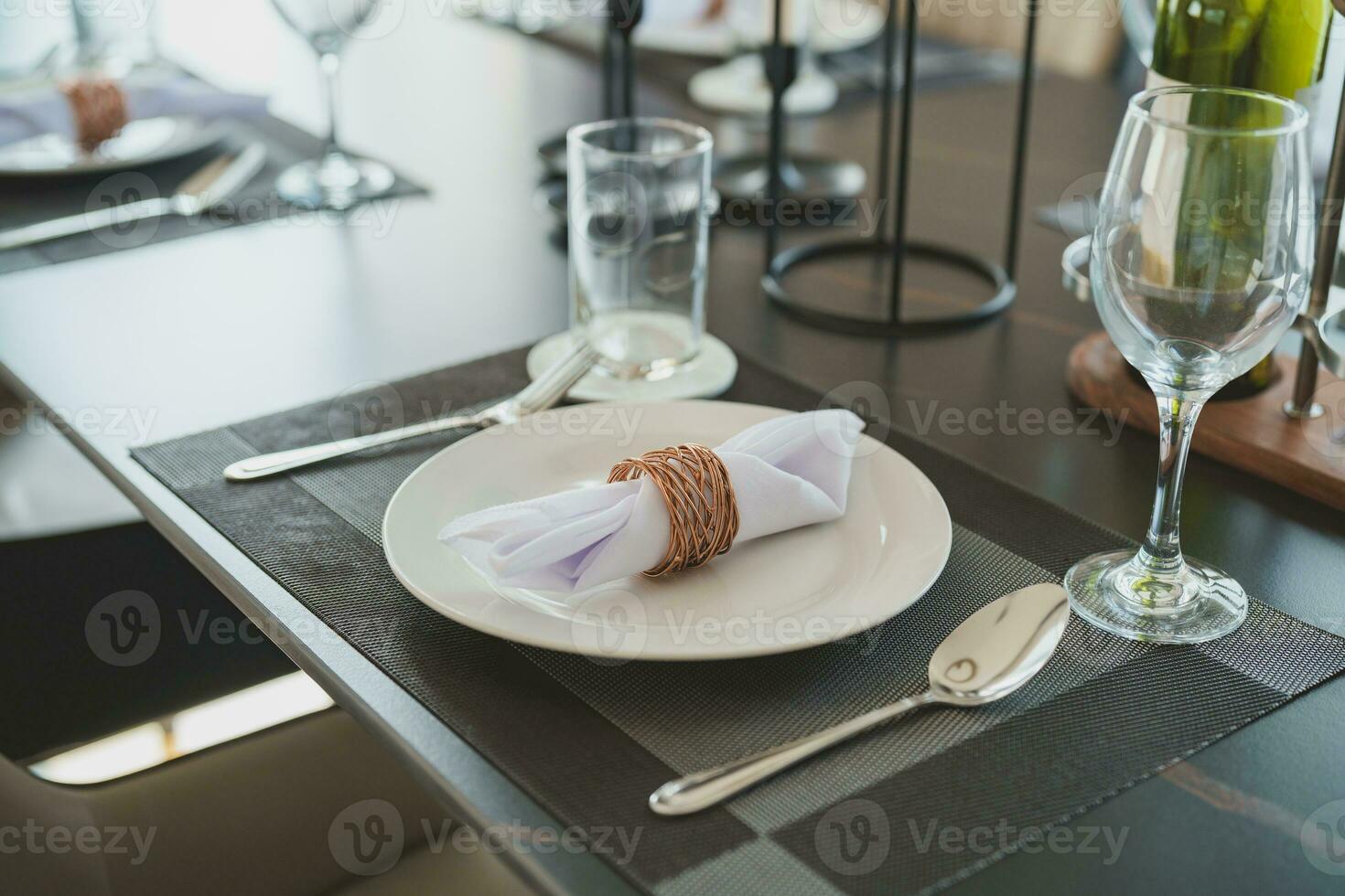 Close-up of plates and cutlery on the dining table. Including wine glasses prepared for customers who will use the service in modern restaurants or hotels. photo